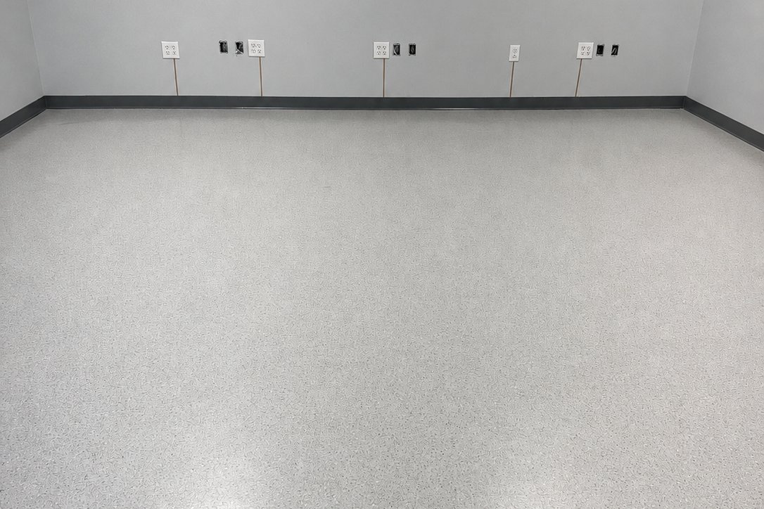 Specialty resinous flake flooring installed by Kenjura Tile in a finished commercial room &mdash; a seamless, slip-resistant, easy-to-maintain surface.