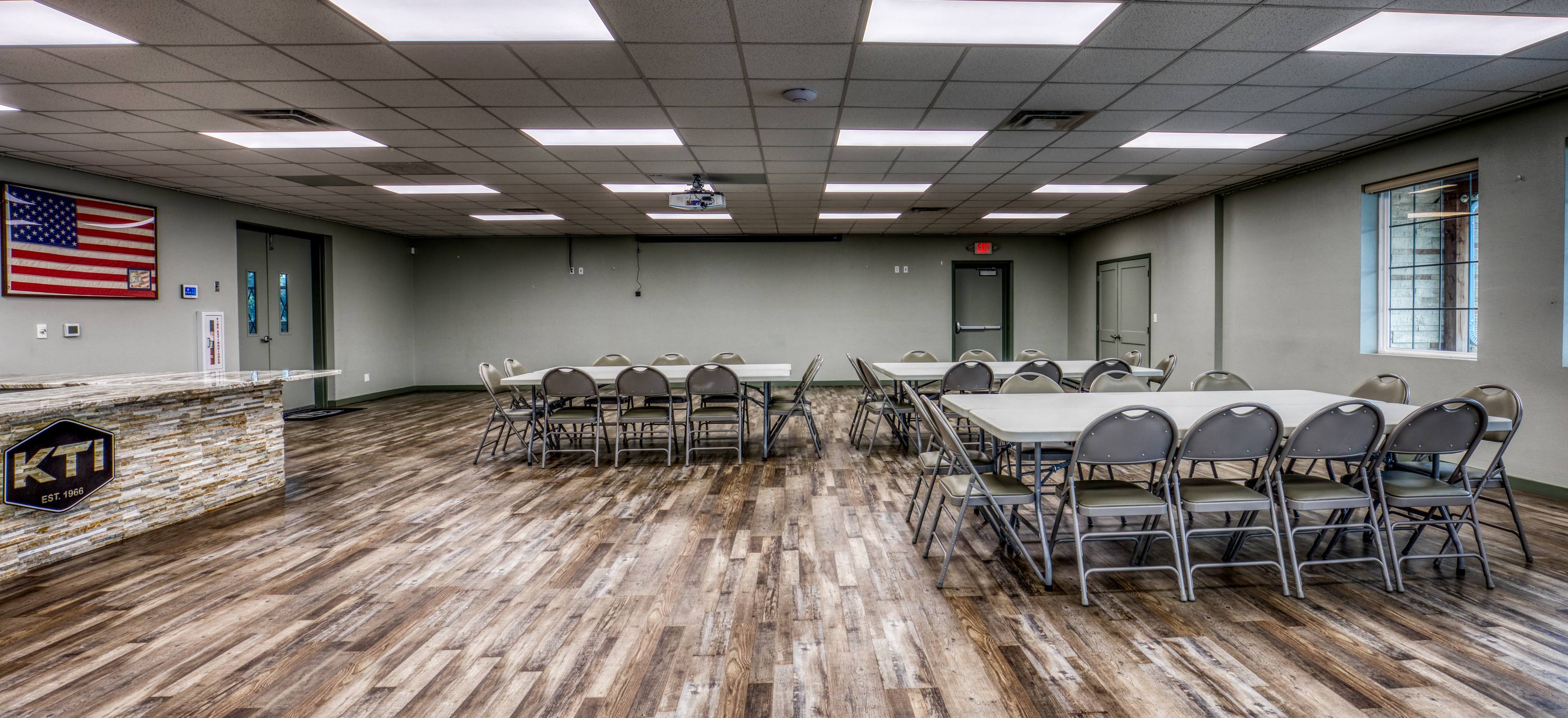 Banquet seating in the main hall with set tables and the Texas flag displayed at the head of the room.
