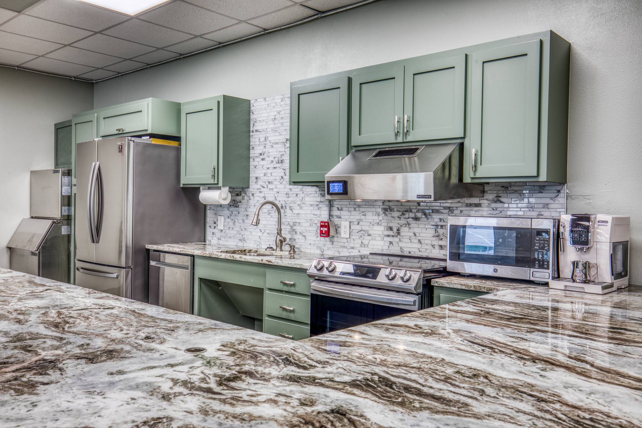 Close-up detail of the Training Center kitchen showing marble counter finish, stainless appliances, and stone-clad bar craftsmanship.